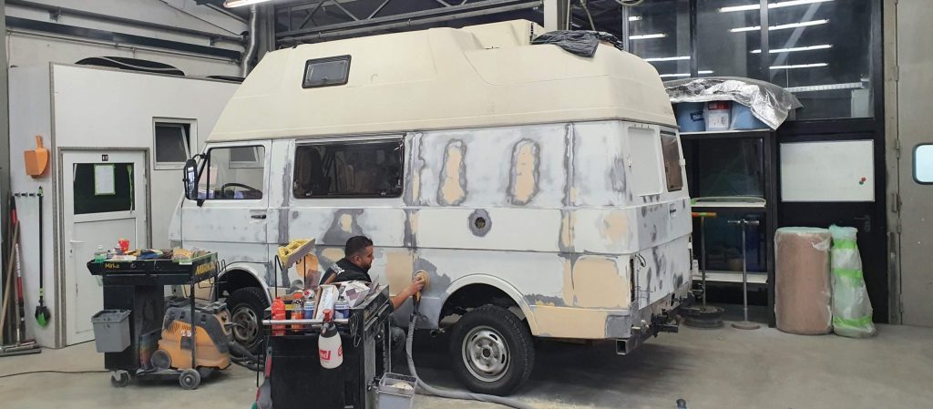 KFZ-Lackierung in Karlsruhe: Wohnmobil-Aufbau wird für die Neulackierung angeschliffen